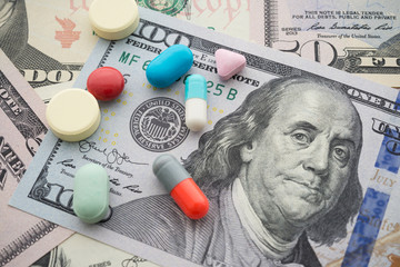 Pills medicine on US dollar banknotes background. World ecomomy crisis, fix or solution USA vs...
