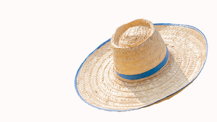Fototapeta na wymiar A brown hat made of straw and a white background