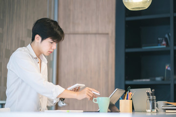 Young man working on computor at her home. Work from home concept.