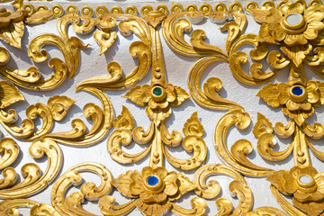 Detail texture background of beautiful painting low relief golden flower of pagoda decoration Lanna thai northern Thailand style, Chiangrai Thailand