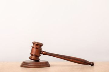 Judge's gavel on table against light background