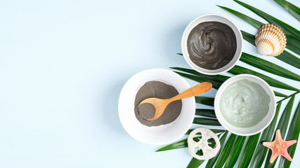 Top view facial clay mask and tropical leaf. Natural organic SPA cosmetic products for skincare, body and hair care concept