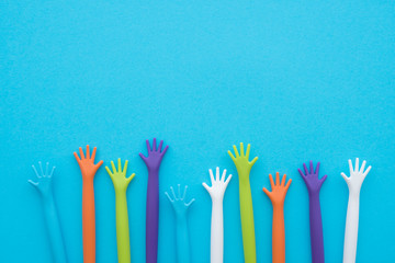Many colorful hands up on blue background with copy space. Concept of international human rights,...