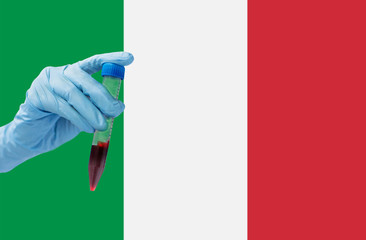 medicine, pandemic and virus concept - close up of hand holding test tube with coronavirus blood test over flag of italy background