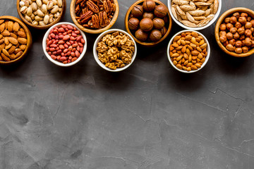 Set of macadamia, hazelnut, walnut, almond, pistachio, pecans nuts on grey background top-down frame copy space