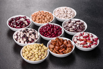 Pulses health food selection in white porcelain dishes over concrete background