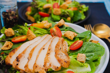 Couple bowl of healthy green vegetable salad on top with tomatos and biscuits. Side dish with salt pepper bottle, white cream and thousand island salad dressing