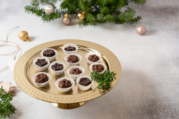 Homemade dark and milk chocolate pralines candies on golden stand. Side view. Christmas candies....