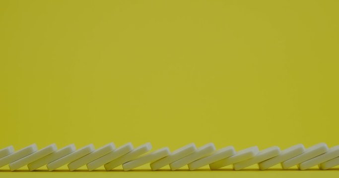 chain reaction when a Domino falls on a yellow background