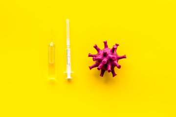 Corona virus Covid-19 - vaccine concept with syringe - on yellow background top-down