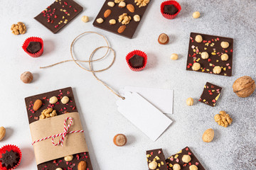Dark chocolate bars with nuts and candies on light background. Homemade organic chocolate. Handmade...