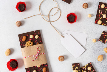 Dark chocolate bars and candies with nuts on light background. Homemade organic chocolate. Handmade...