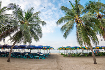 Beach chairs and colorful umbrella on tropical beach in summer holiday with sunny day blue sky background. Travel summer tropical beach holiday concept.