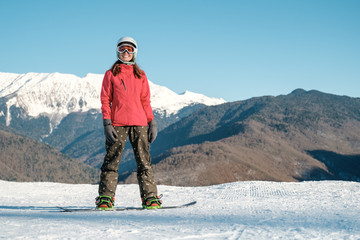Picture of happy young lady snowboarder on the slopes