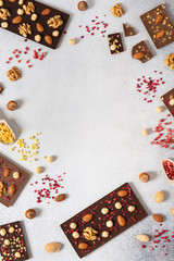 Milk and dark chocolate bars with nuts and dried fruits chocolate candies on white background,...