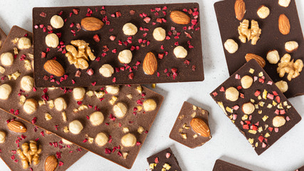 Variety of dark and milk chocolate bars with nuts and dried fruits. Handmade organic chocolate. Top...