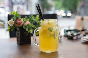 Glass of yellow alcohol-free cocktail with lemons and mint
