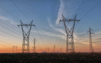 High-voltage power lines at sunset, high voltage electric transmission tower. Industrial concept.