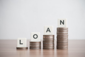 Word LOAN on step stack coins as graph up. Business and finance concept. Interest and fees from...