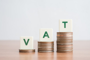 Word VAT on step stacked coins as graph up over white background. Vat concept. Value Added Tax is an indirect tax imposed on the value added of each stage of production and distribution.