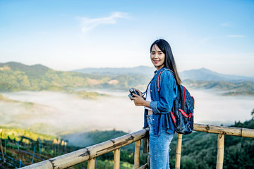 asian tourist traveler girl in an adventure traveling on the mountains, using a digital camera...