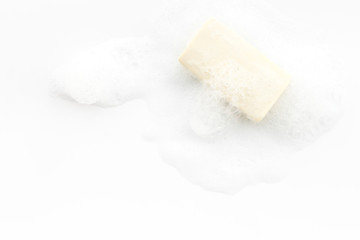 Soap bar with foam on white background top-down copy space