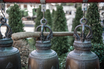 Fototapeta premium Bronze bells and a wooden stick