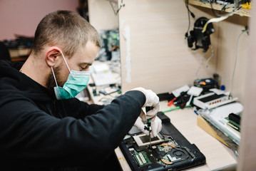 Technician repairing a laptop in the lab. Concept of repair computer, electronic, upgrade,...