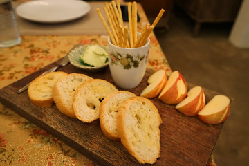 Close up butter bread appetizer served with sliced apple on wooden tray table