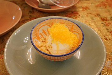 Close up Vanilla ice cream served with crumble and Fios de ovos (golden egg yolk floss thread)