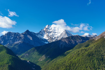 Daocheng Yading natural scenic area in Sichuan, China in spring; towering snowy mountains