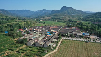 Fototapeta na wymiar Aerial view of Chinese rural landscape, houses and green mountains