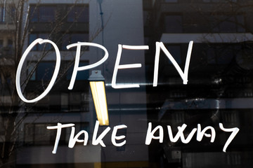 Sign on window of cafe/restaurant/bistro saying "Open, take away"