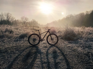 Fototapeta na wymiar Mountain bike on the trail against colorful sunset