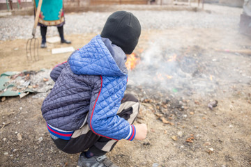Boy playing with fire in the yard