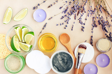 Natural ingredients in bowls top view for making facial clay mask with lavender herb and aromatic essential oil of lime for healthy skin care & beauty treatment.  Homemade spa cosmetic recipe