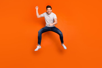 Full length photo of funky guy jump high up pretending horse riding rushing speed fast excited mood...
