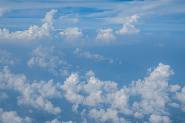 Blue sky with white curly fluffy clouds.