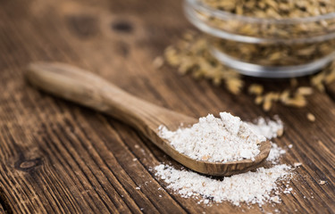 Wooden table with Oat Flour (detailed close-up shot; selective focus)