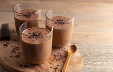 Homemade chocolate mousse made of dark chocolate,eggs, fresh cream and sugar on a wooden table. Top...
