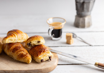 Breakfast table with croissants and cinnamon buns with fresh orange juice.