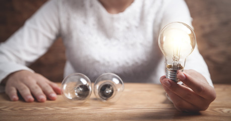 Business girl holding light bulb. Creativity