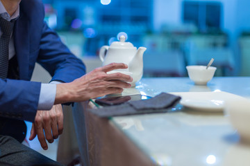 Business man pours tea in a cafe or restaurant