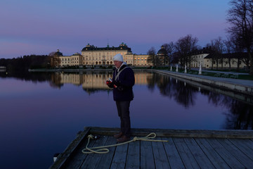 Stockholm, Sweden  A man drinks thermos coffee at dawn at Drottningholm 
