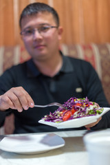 man eating coleslaw in a restaurant