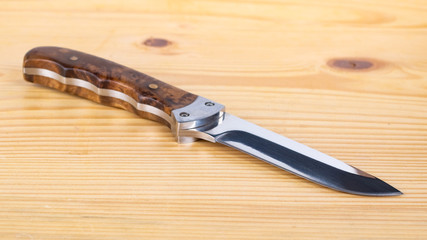 Beautiful hunting knife isolated on the wooden table