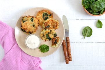 Pancakes with cabbage and spinach. Juicy vegetable cutlets on a plate with sour cream. Diet menu. Lenten dish. The top view