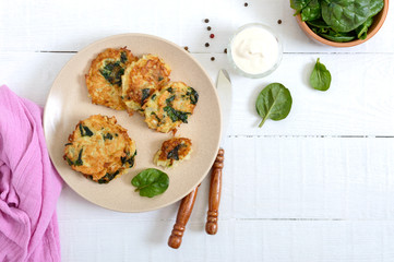 Pancakes with cabbage and spinach. Juicy vegetable cutlets on a plate with sour cream. Diet menu. Lenten dish. The top view
