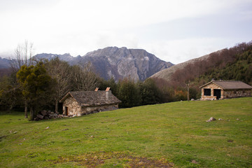 paisaje montañoso con una cabaña al fondo