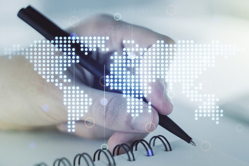 Abstract creative digital world map and man hand writing in diary on background, globalization...